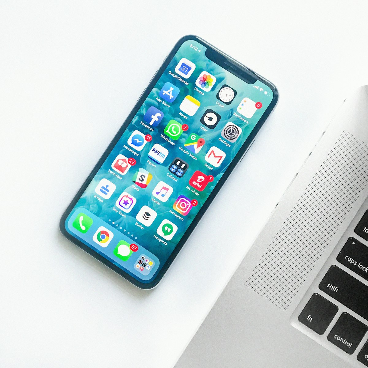 Ponsel dengan layar aplikasi di samping laptop